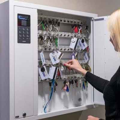 Woman selects a key from a Key Box System